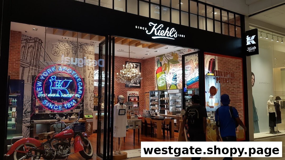 The storefront of Kiehl's, featuring a vintage motorcycle, neon sign, and a glimpse into its unique apothecary-style interior.