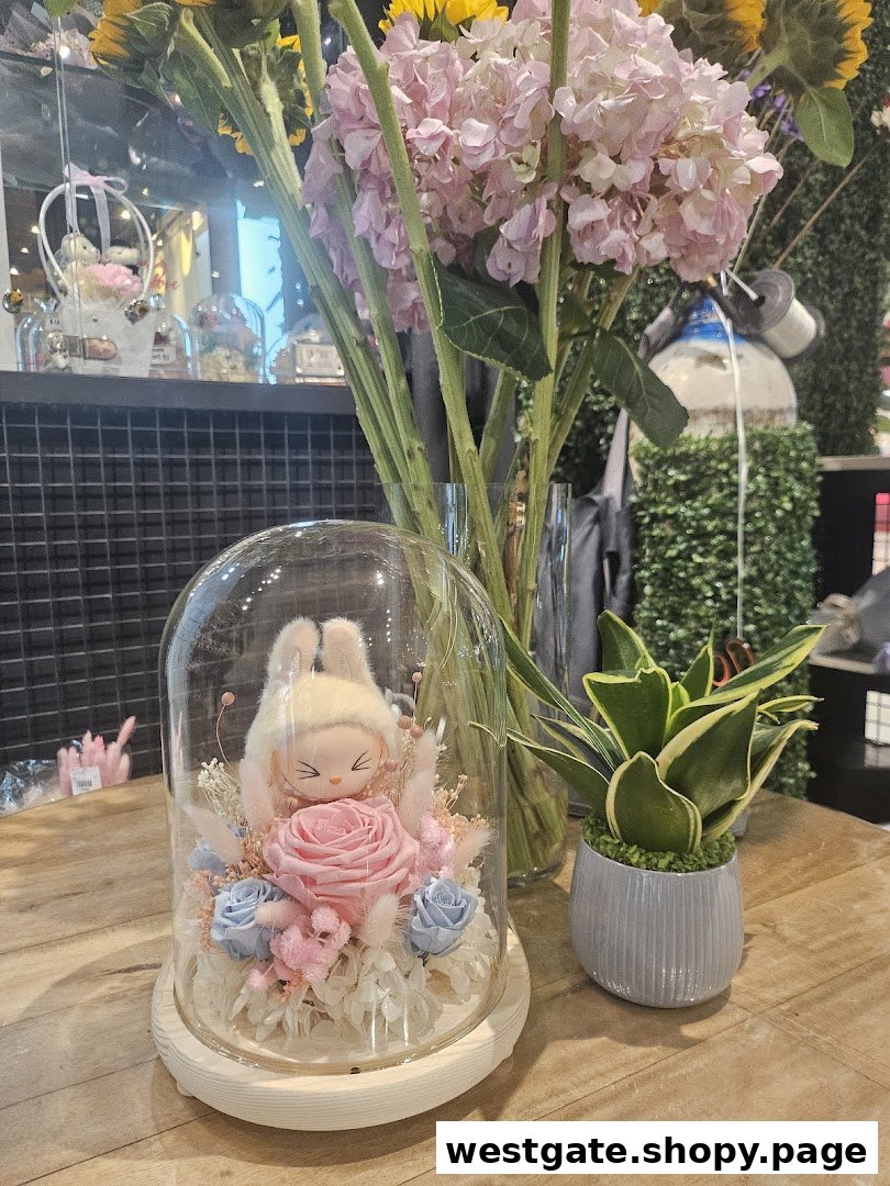 A charming floral arrangement with a plush toy under a glass dome, alongside a potted plant.
