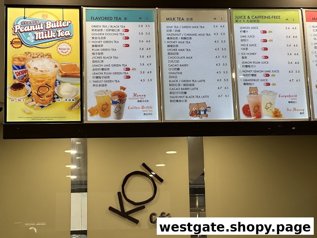 A brightly lit menu board at KOI Thé, showcasing various tea, milk tea, and juice options.