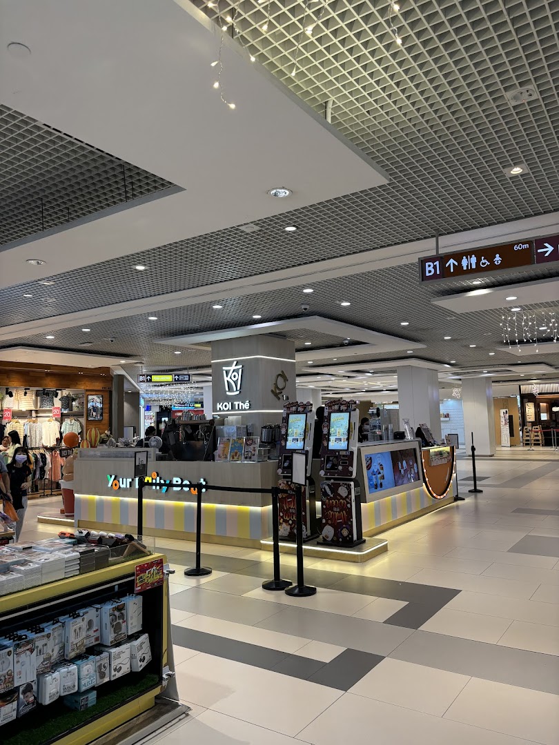 A vibrant KOI Thé bubble tea kiosk with colorful counter design inside Westgate Mall.