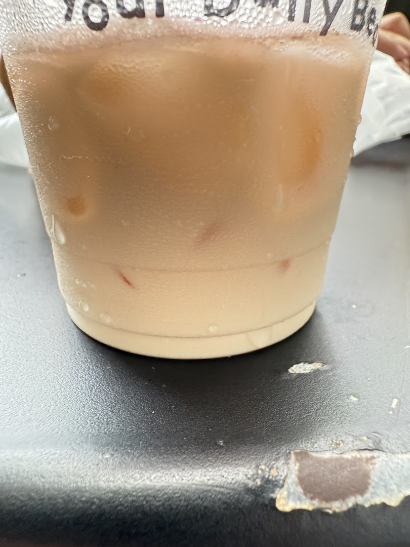 A close-up of a refreshing iced beverage in a clear cup with condensation.