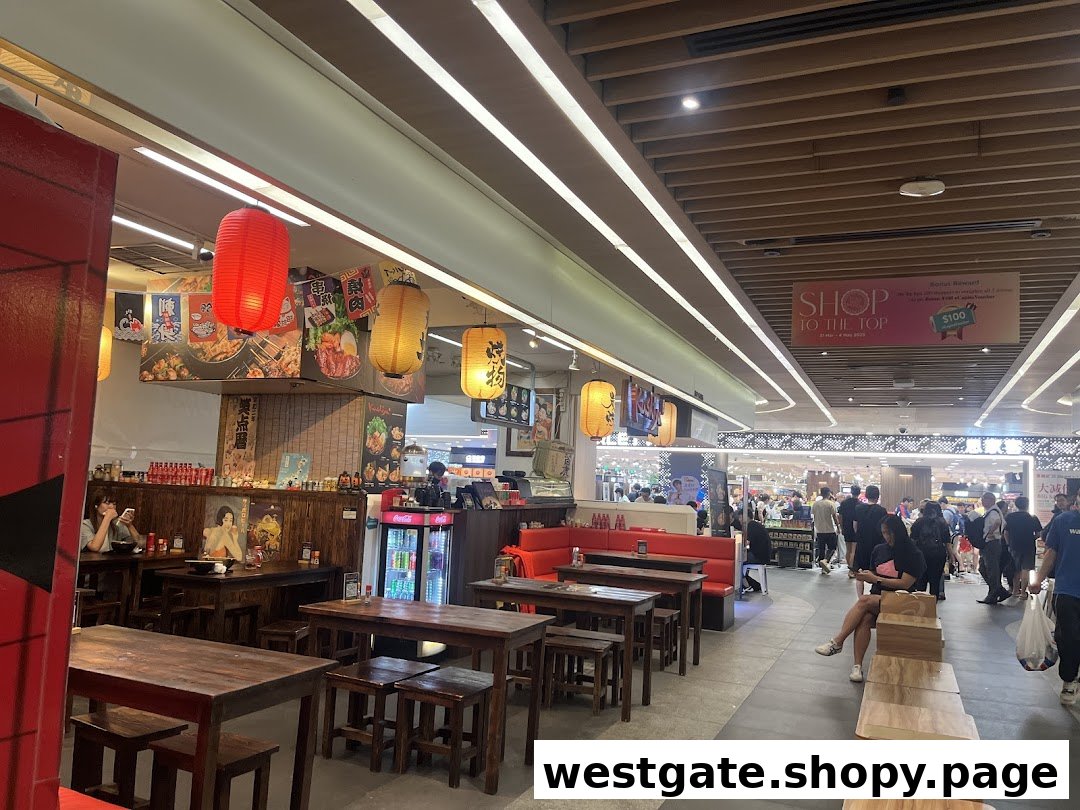 Interior view of Kushiya Japanese Grill House, featuring traditional wooden tables, red lanterns, and a lively mall backdrop.