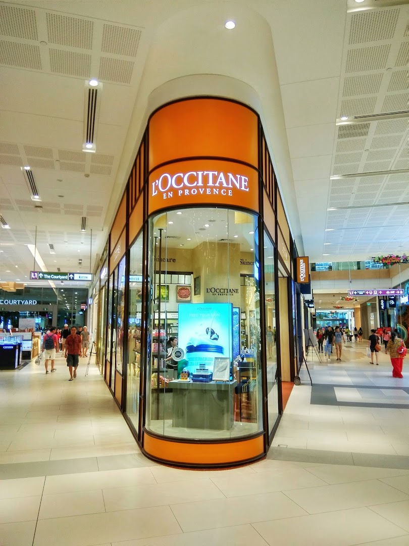 The L'OCCITANE en Provence shop front with its distinctive orange signage and glass display in a mall.