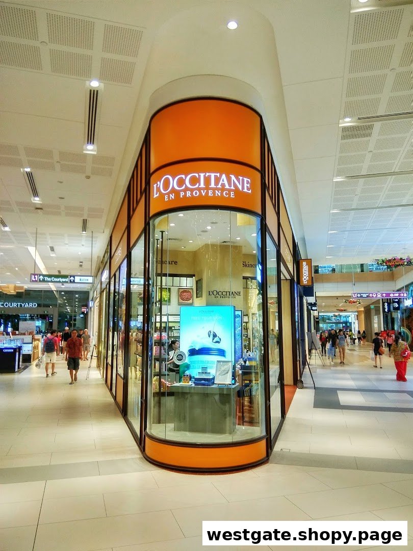 The L'OCCITANE en Provence shop front with its distinctive orange signage and glass display in a mall.