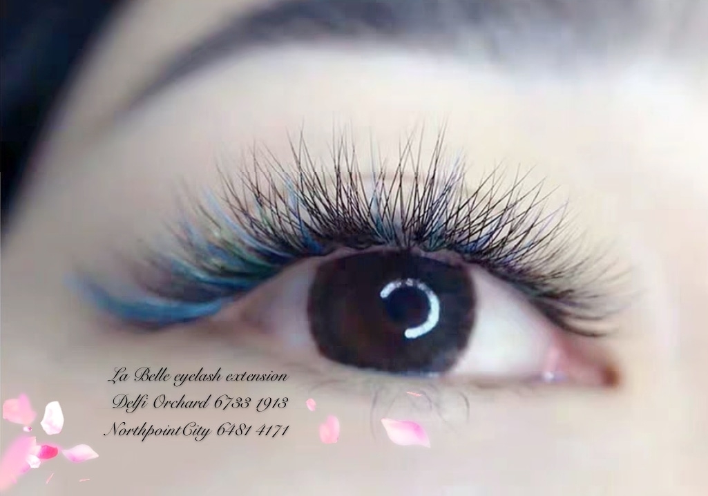 Close-up of an eye showcasing vibrant blue and black eyelash extensions.