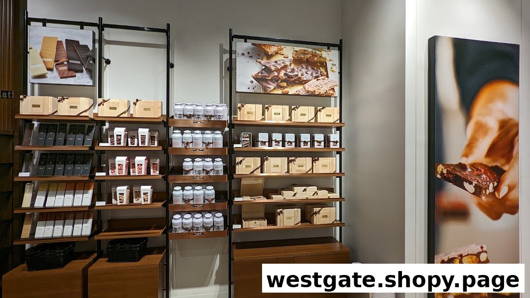 Interior view of a chocolate shop displaying various premium chocolate bars, gift boxes, and confections on shelves.