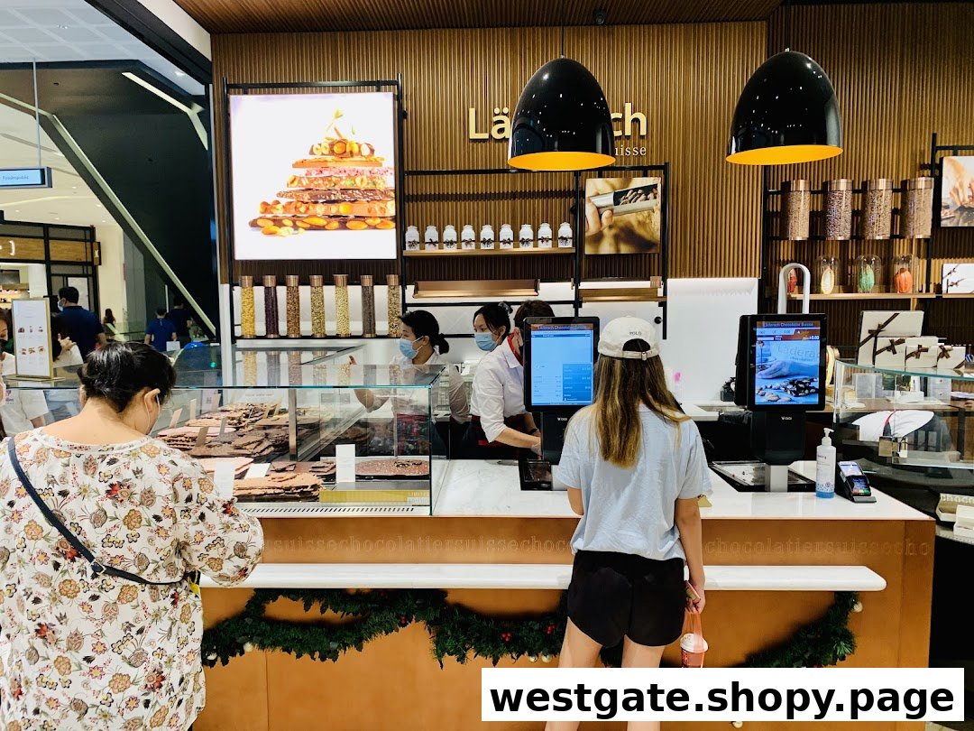 Customers browse and purchase exquisite chocolates at the Läderach counter, showcasing a vibrant retail experience.