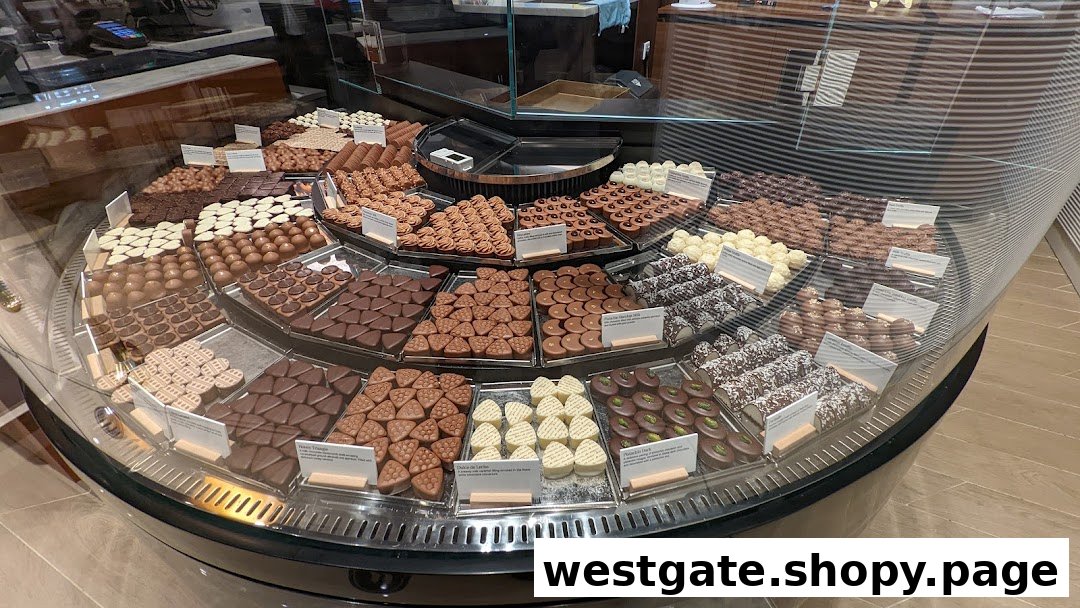 A vibrant display of assorted gourmet chocolates and pralines in a circular glass case.