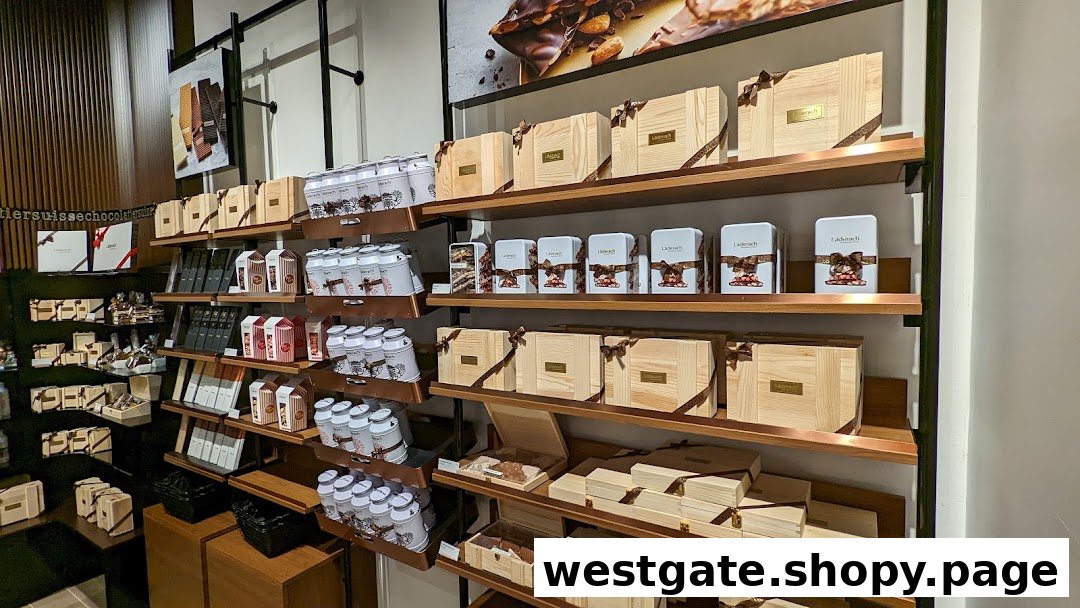 An interior view of Läderach chocolate shop, showcasing shelves filled with various chocolate products and gift boxes.