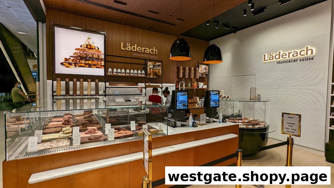 Interior view of Läderach chocolate shop, showcasing fresh chocolate displays and a welcoming counter area.