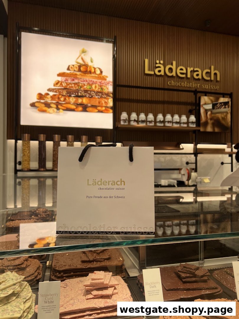 A vibrant display of artisanal chocolates and a branded shopping bag inside a Läderach store.