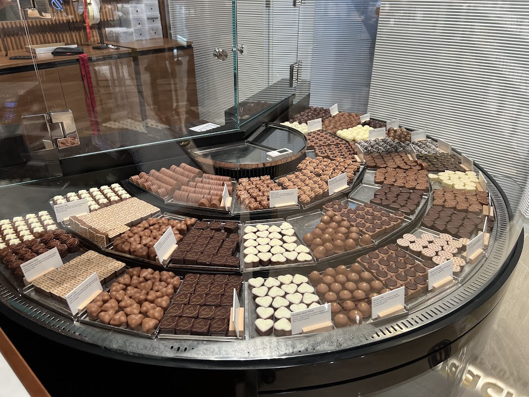 A vibrant display case showcasing a wide variety of fresh Läderach chocolates and pralines.