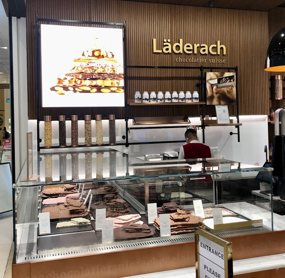 Interior view of a Läderach chocolate shop featuring a display of fresh chocolates.