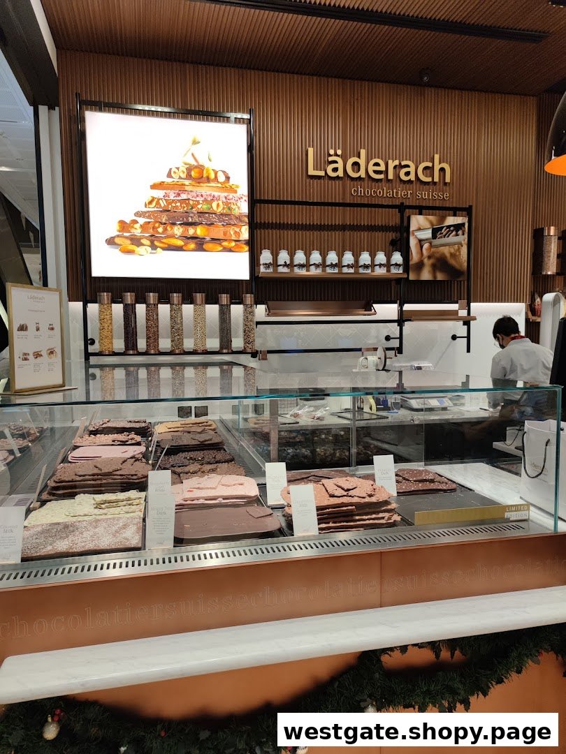 Interior view of Läderach chocolate shop, showcasing fresh chocolate slabs and a staff member.