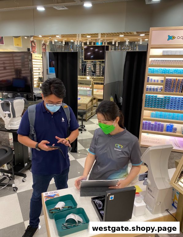 A customer consults with a Lenskart staff member inside the eyewear store, surrounded by optical equipment and products.