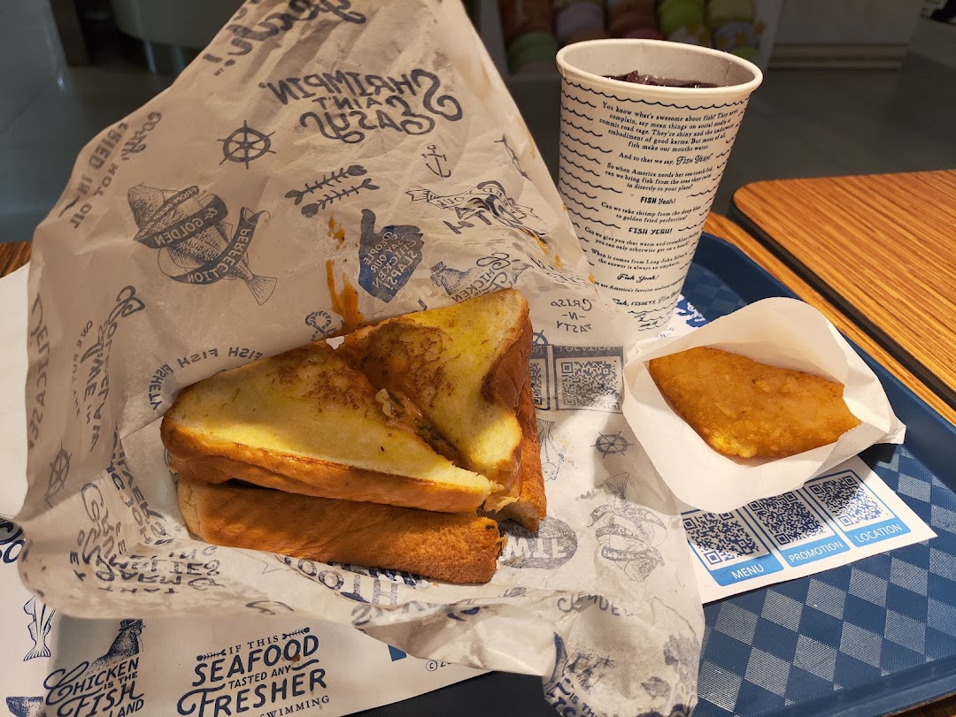 A meal from Long John Silver's featuring a sandwich, hash brown, and drink on a tray.
