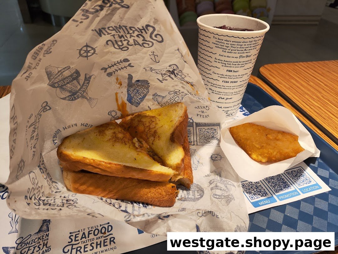 A meal from Long John Silver's featuring a sandwich, hash brown, and drink on a tray.