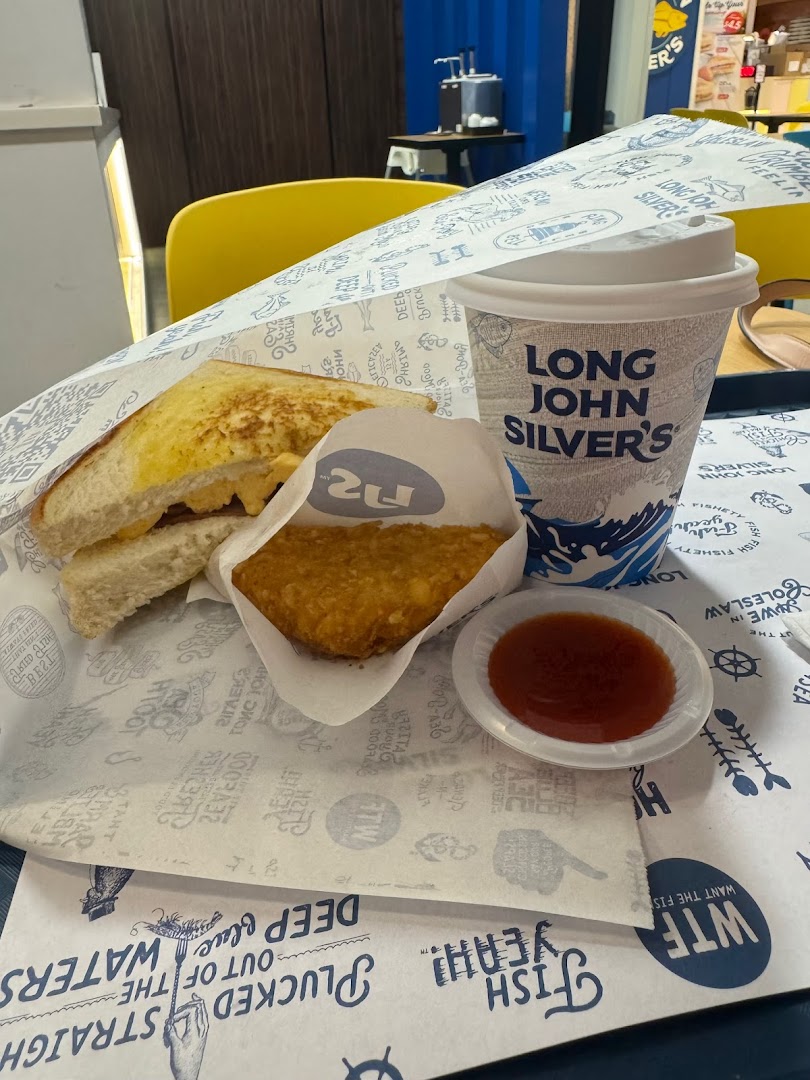 A Long John Silver's meal featuring a sandwich, hash brown, sauce, and branded drink cup on a tray.