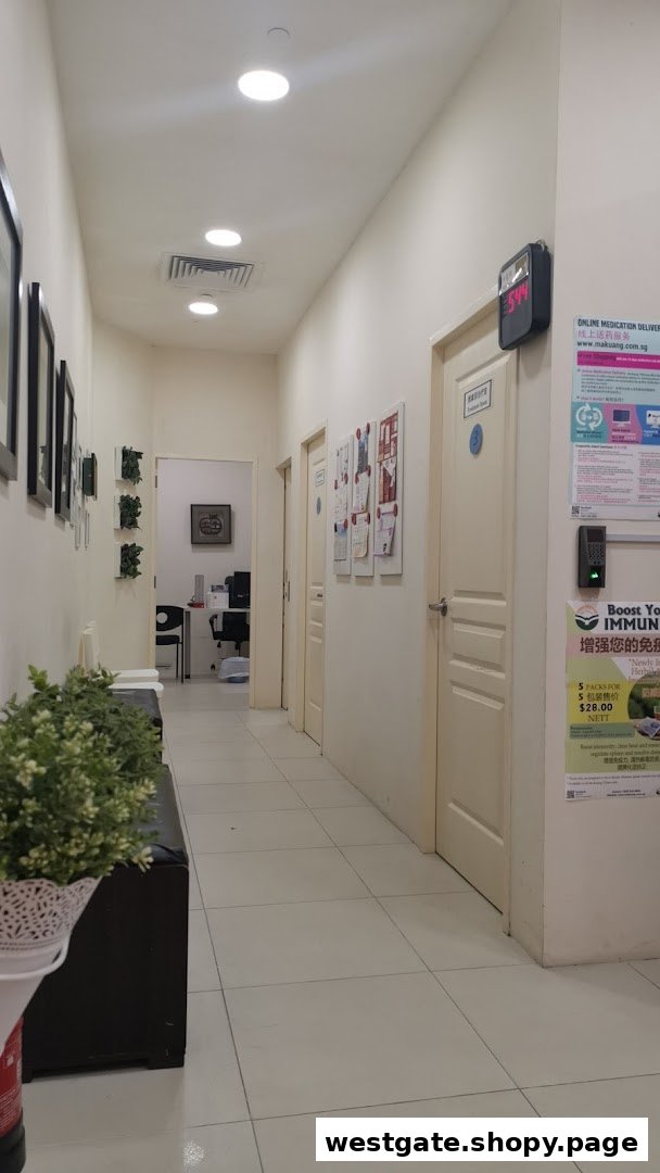 A well-lit interior hallway of Ma Kuang TCM Clinic, featuring multiple doors and informational posters.