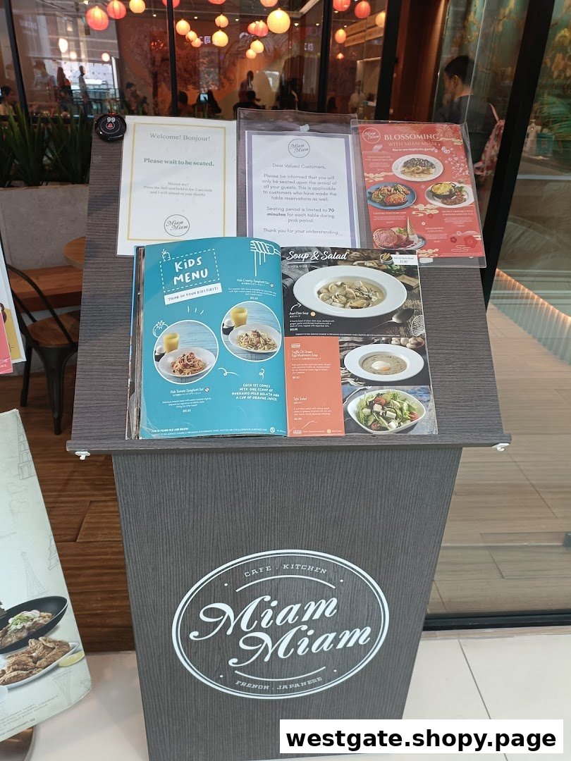 The entrance of Miam Miam French Japanese Cafe Kitchen, featuring a welcome stand with menus.