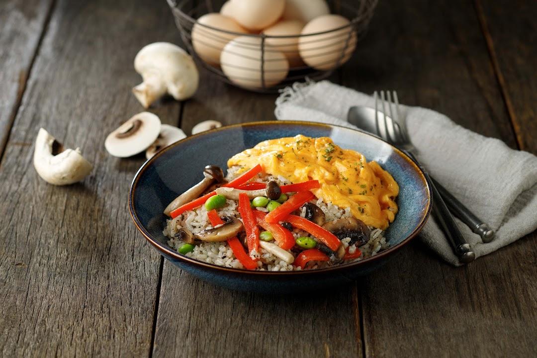 A vibrant bowl of rice topped with creamy scrambled eggs, sautéed mushrooms, and red bell peppers.