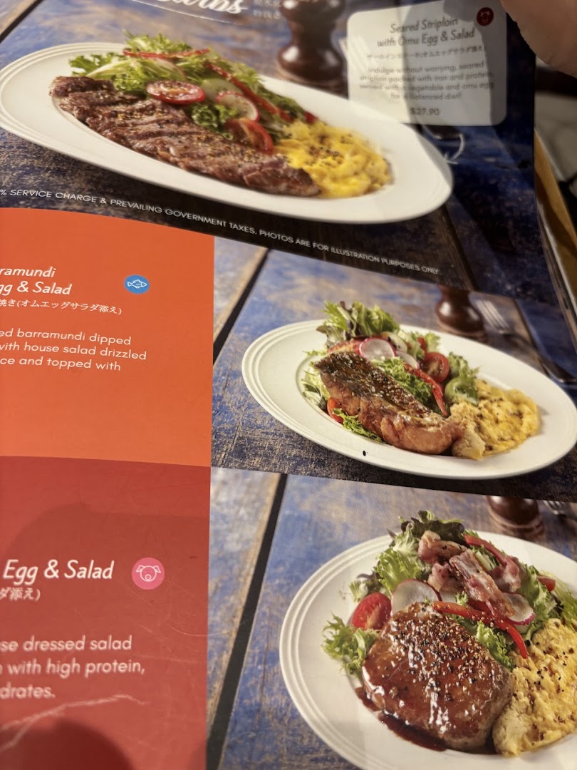 A close-up of a menu page showcasing various French-Japanese fusion dishes with accompanying descriptions and prices.