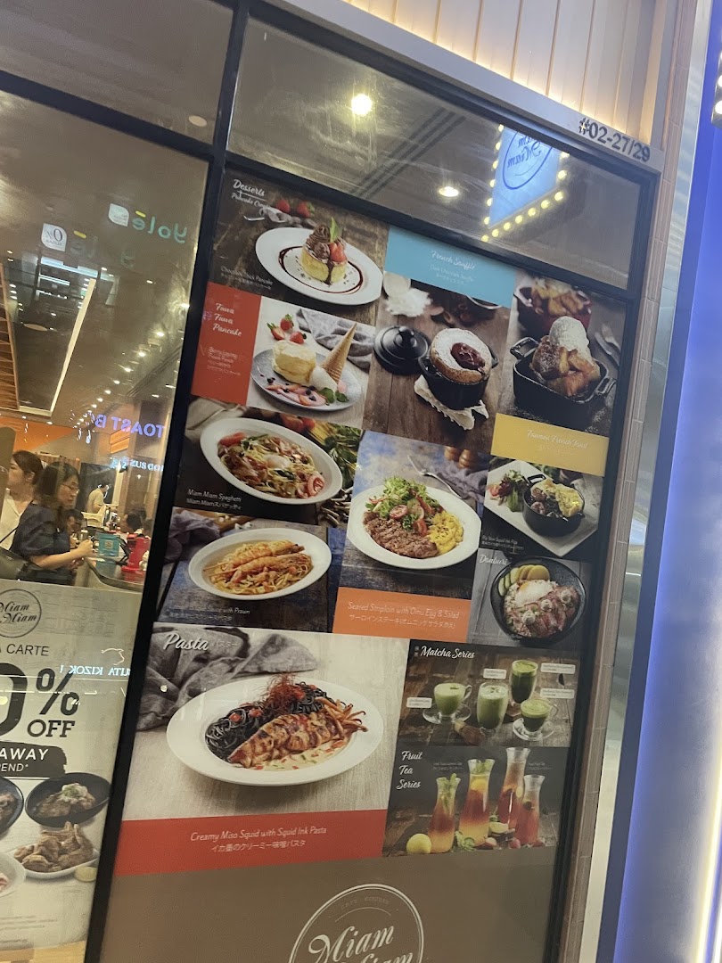 A vibrant display board showcasing Miam Miam's French-Japanese fusion dishes and beverages.