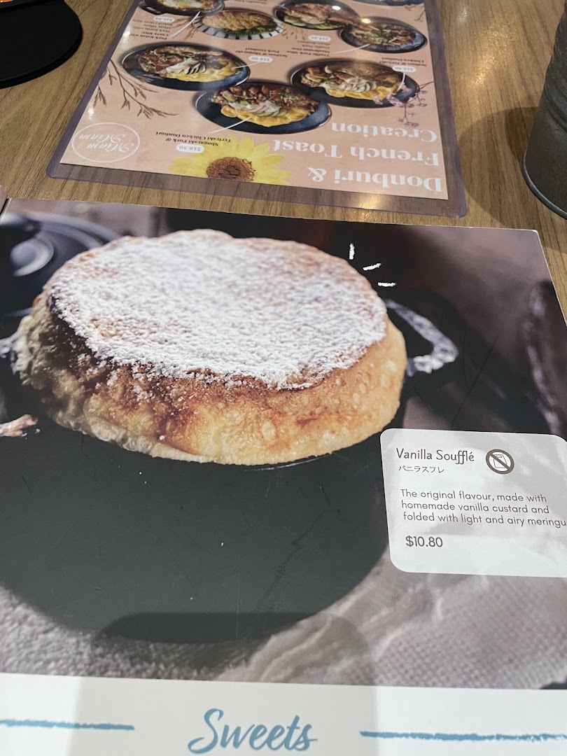 A close-up of a menu displaying a Vanilla Soufflé and other Japanese-French fusion dishes.
