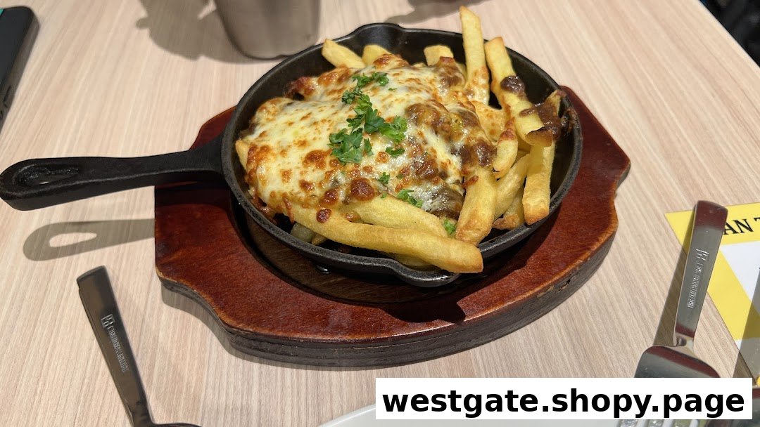 A cast iron skillet filled with golden fries topped with melted cheese and gravy.