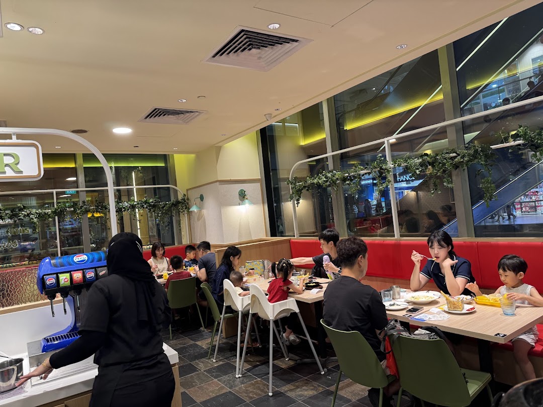 Diners enjoying meals in a brightly lit, spacious restaurant interior with large windows.