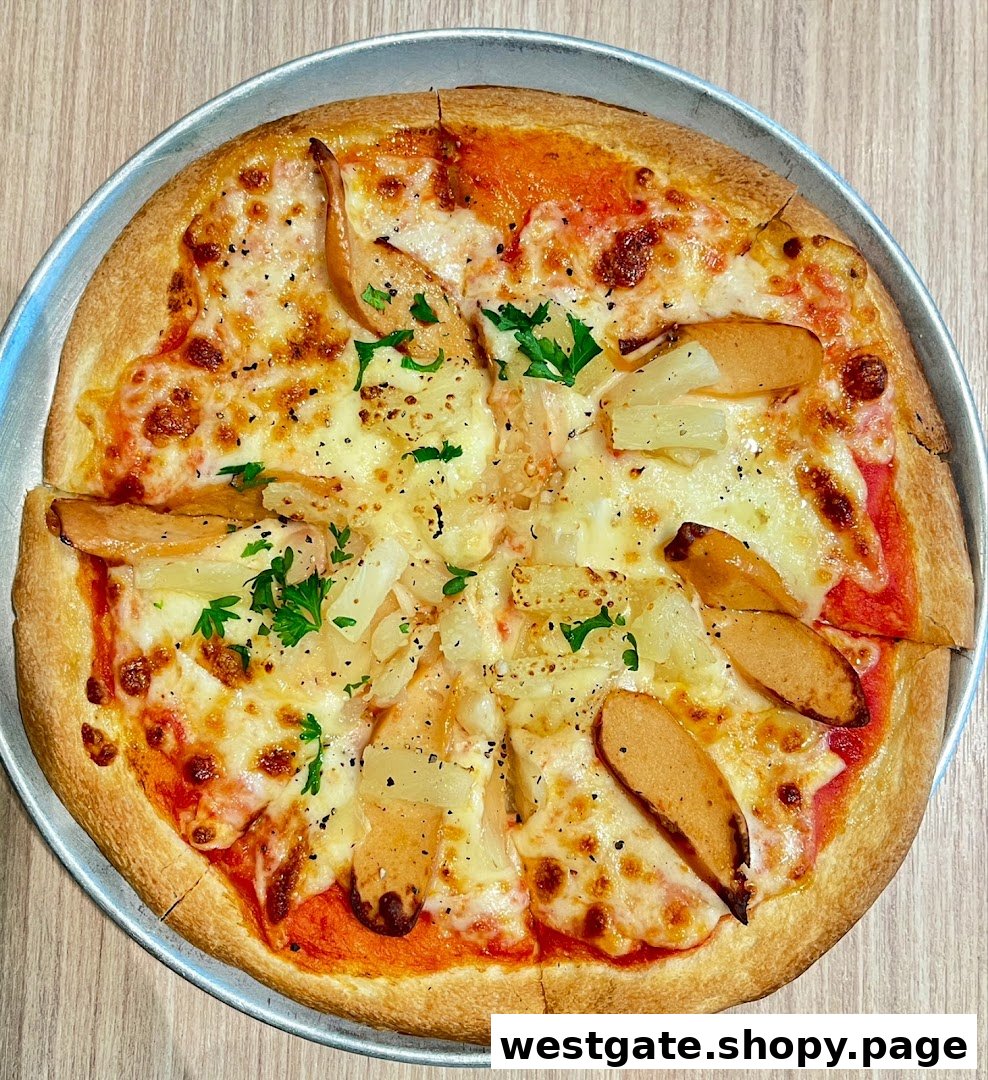 A delicious pizza topped with melted cheese, sausage slices, and pineapple chunks on a metal tray.