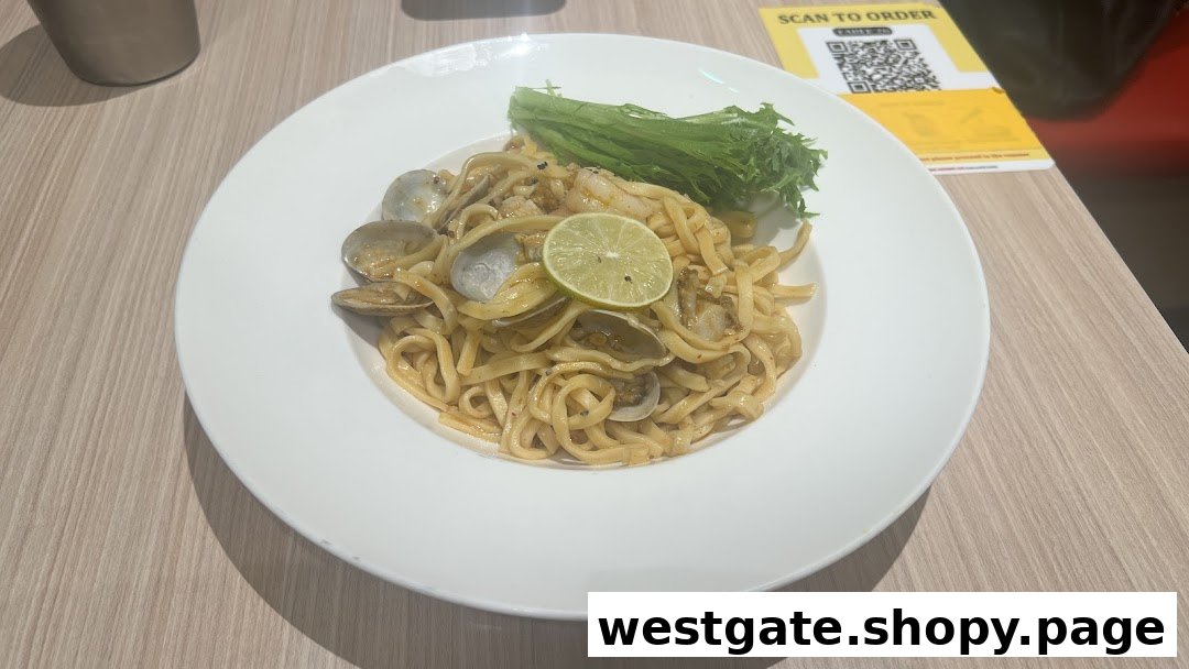 A delicious plate of pasta with clams, shrimp, fresh lime, and crisp lettuce at Milan Shokudo.