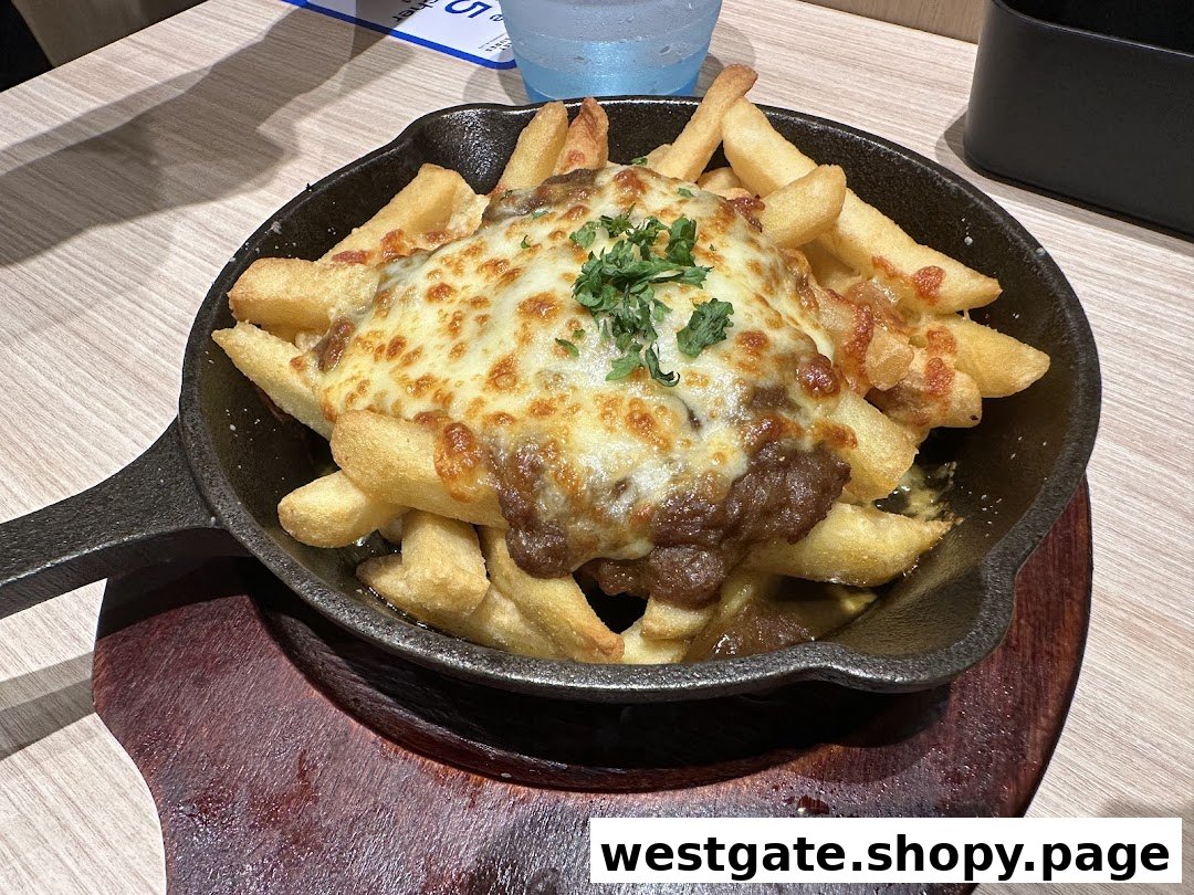 A close-up of crispy french fries topped with savory meat sauce and melted cheese in a skillet.