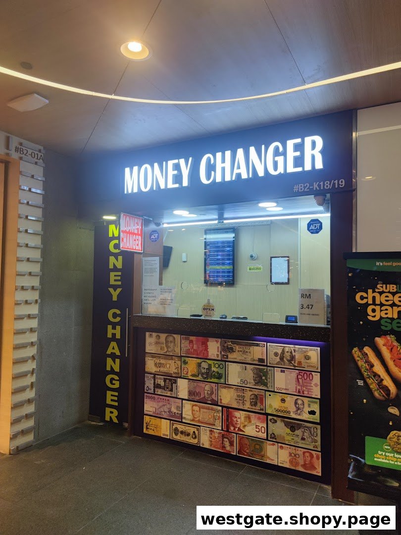 The brightly lit storefront of a money changer, featuring a display of various international currencies.