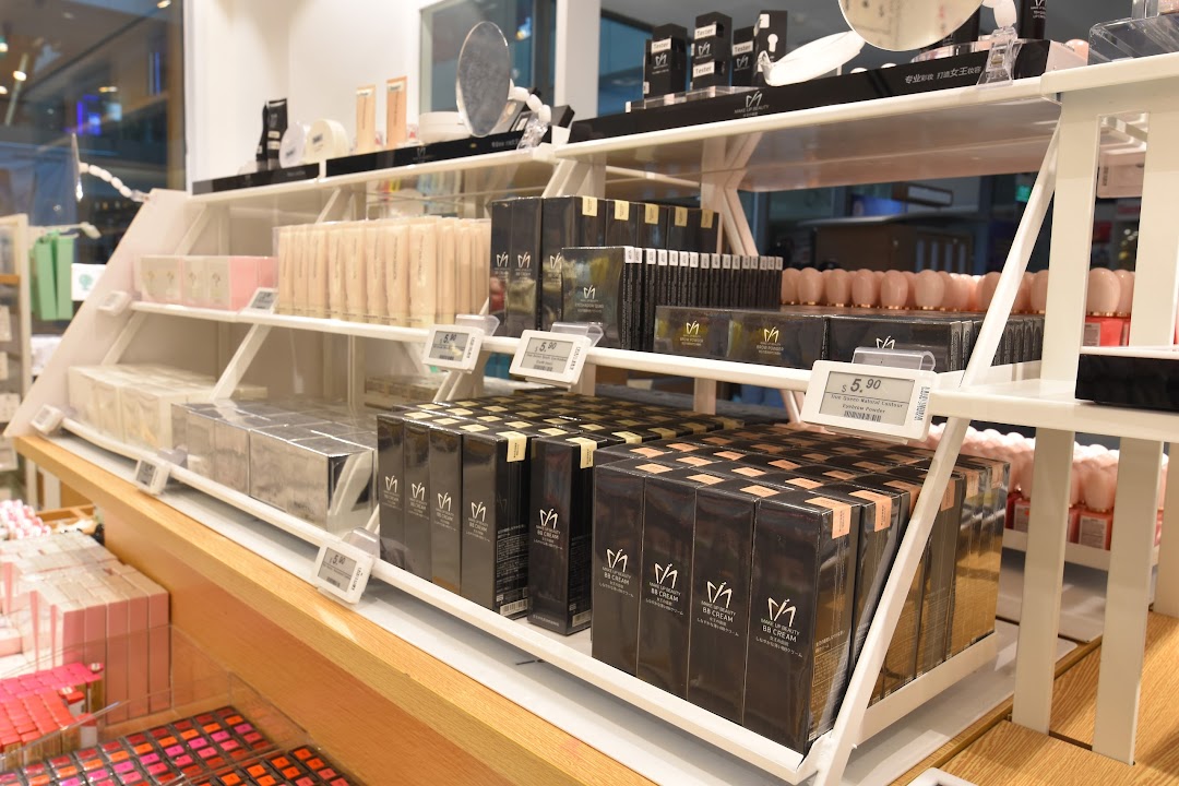Shelves displaying a variety of beauty and cosmetic products, including BB creams and eyebrow powders, inside MINISO.