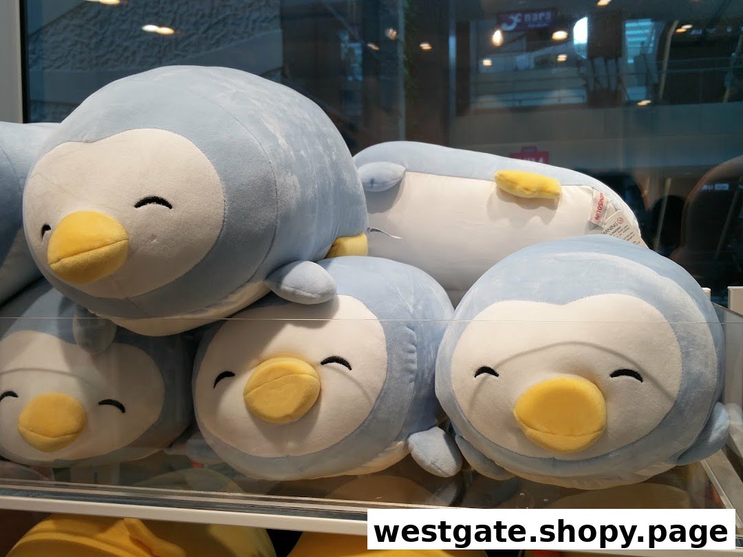 A display of adorable light blue penguin plush toys with happy faces at MINISO.