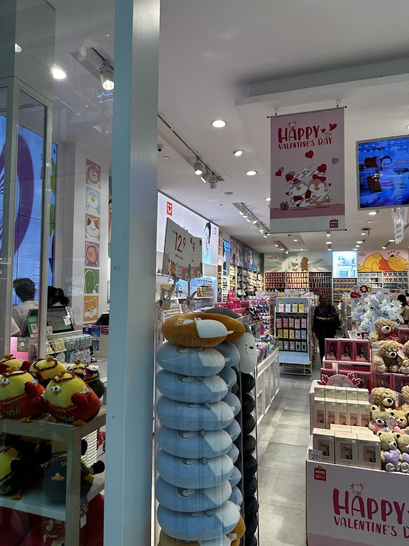 A vibrant interior view of MINISO, showcasing diverse products, plush toys, and a festive Valentine's Day display.