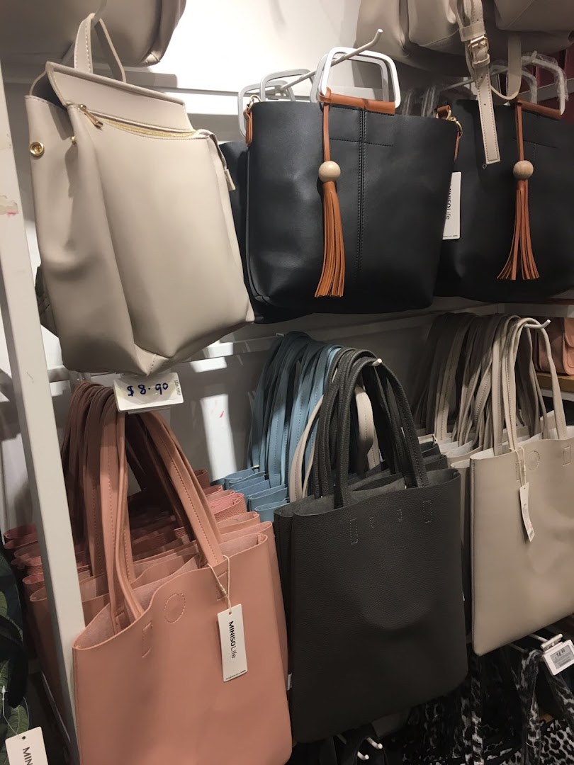 A vibrant display of MINISO's trendy handbags and backpacks in various colors and styles.