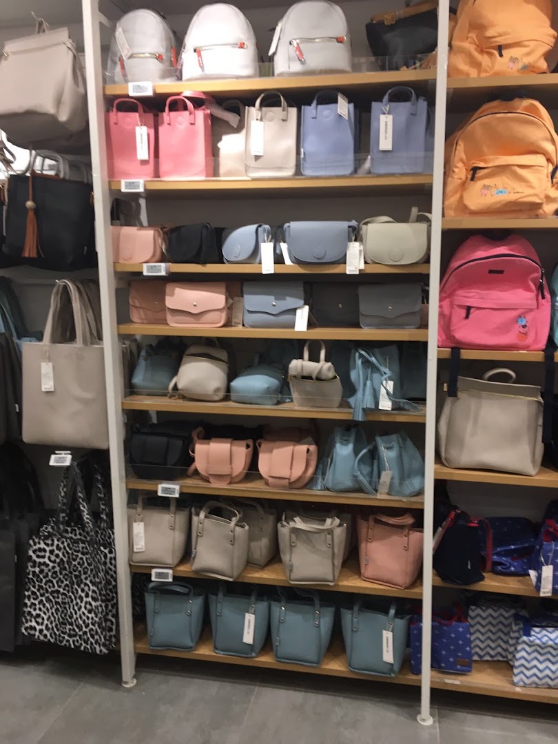 Shelves at MINISO Westgate displaying a wide variety of colorful and stylish bags and backpacks.
