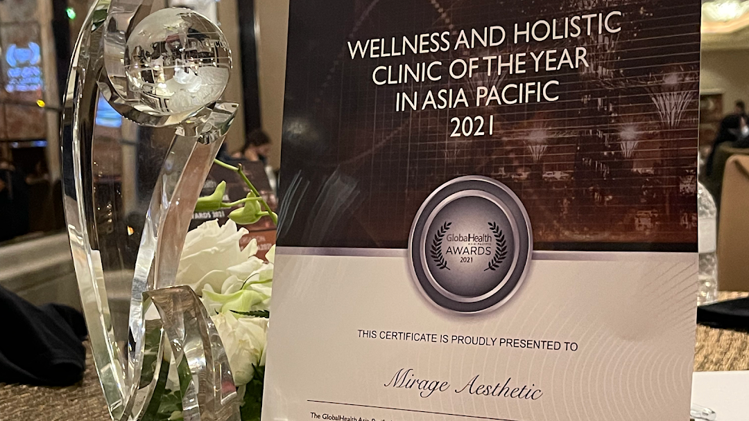 A crystal award trophy and a certificate recognizing Mirage Aesthetic as 'Wellness and Holistic Clinic of the Year'.