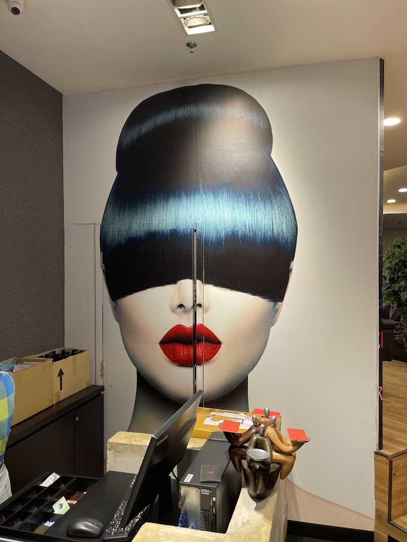 An interior view of Mister Minit Westgate featuring a service counter, computer, and a large graphic of a woman's face.