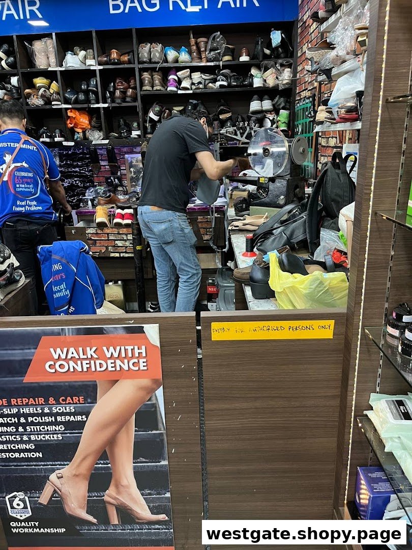 Two technicians diligently work on shoe and bag repairs within a busy Mister Minit shop.