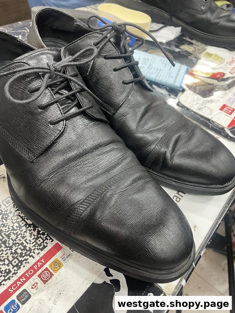 Close-up of black shoes on a counter, ready for repair or service at Mister Minit.