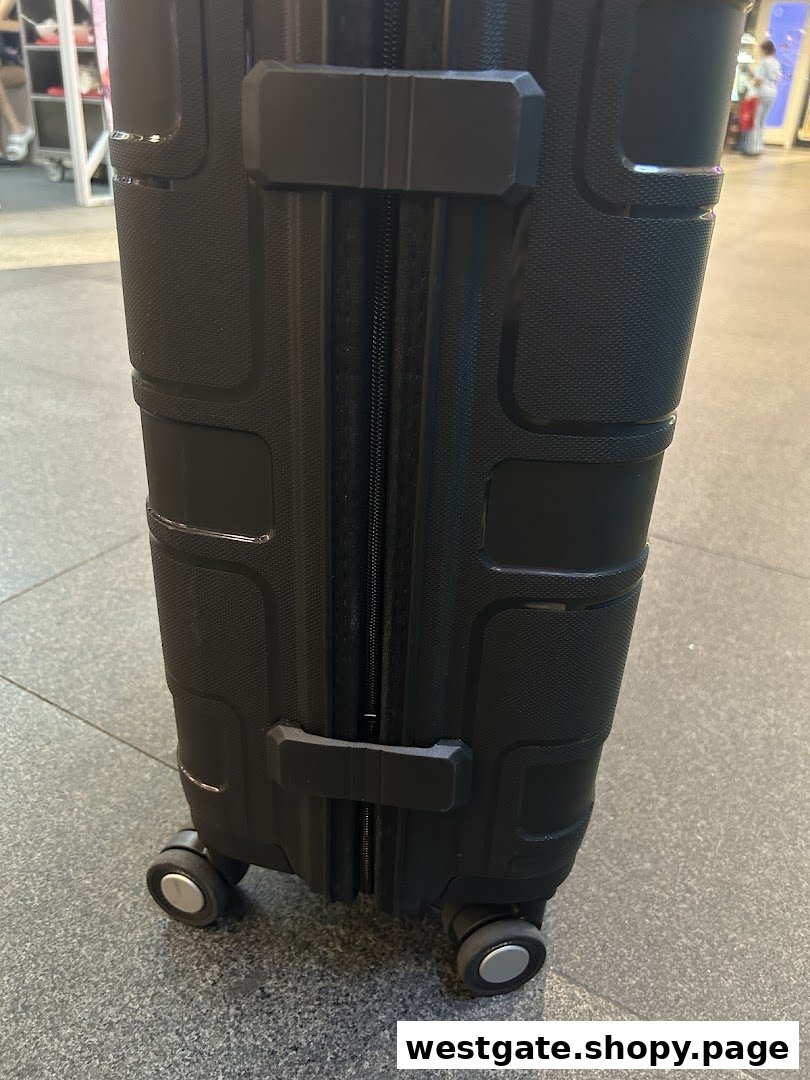 Close-up of a black, textured suitcase with wheels on a tiled floor.