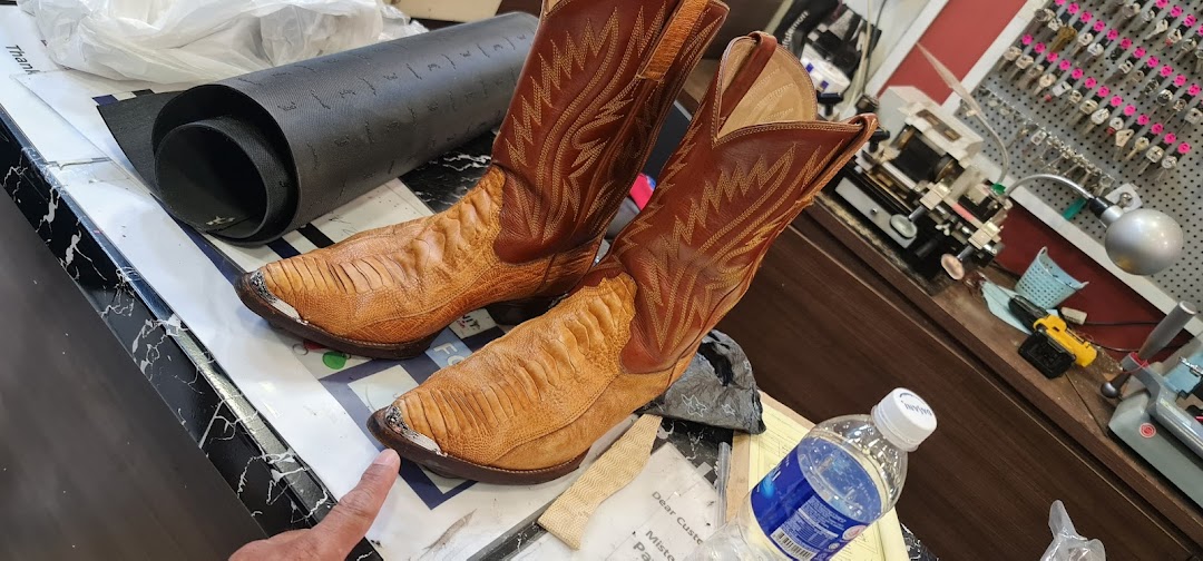 A pair of cowboy boots on a counter at Mister Minit, with key cutting equipment visible in the background.
