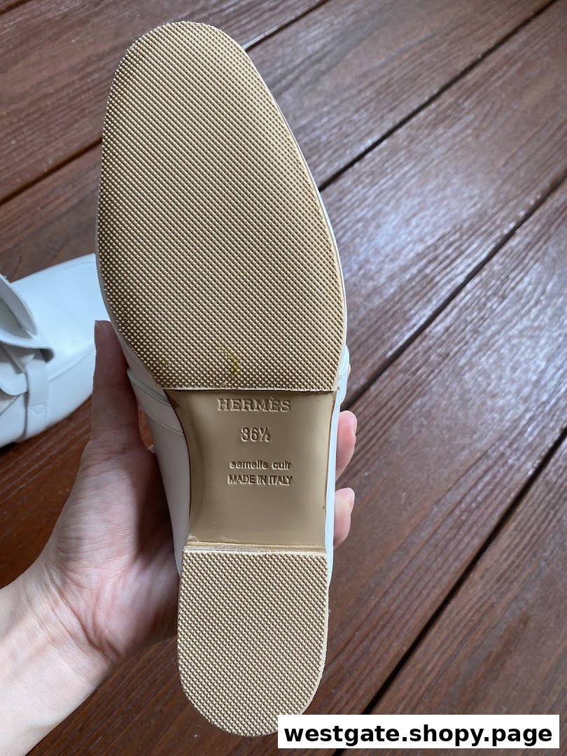 Close-up of a white shoe's sole, revealing 'Hermes' branding and 'Made in Italy' details.