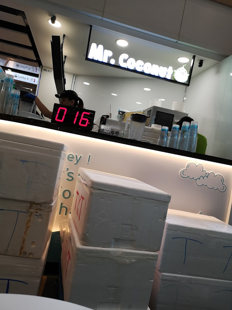 Interior view of Mr. Coconut shop with staff preparing drinks and visible equipment.