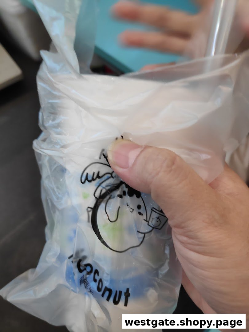 A hand holds a Mr. Coconut drink in a clear plastic bag with the brand's logo.