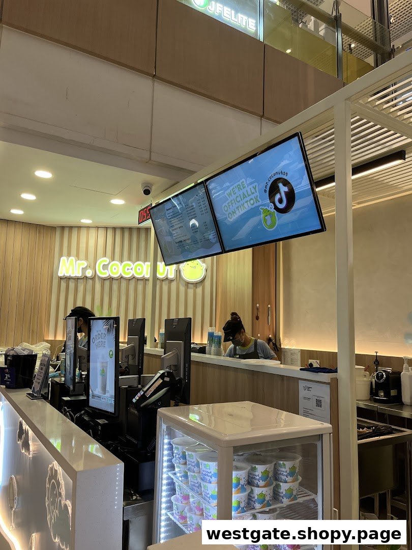 Interior view of Mr. Coconut shop, showing the service counter, staff, and digital displays.