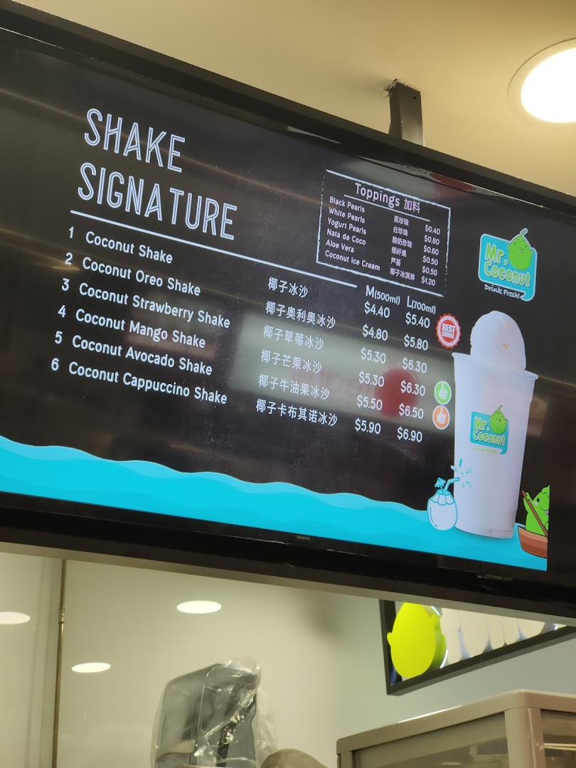 A digital menu board displaying signature coconut shakes and toppings with prices at Mr. Coconut.
